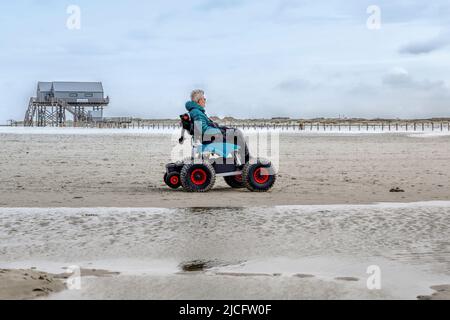 Mann im Strandrollstuhl, Sankt-Peter-Ording, Schleswig-Hostein, Deutschland Stockfoto