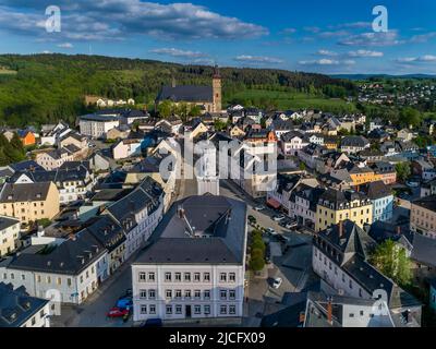 Stadtzentrum von Schneeberg: Die sächsische Stadt Schneeberg liegt an der Silberstraße im oberen westlichen Erzgebirge. Blick über das Rathaus auf die markante St. Wolfgang Kirche, die von weitem zu sehen ist. Stockfoto