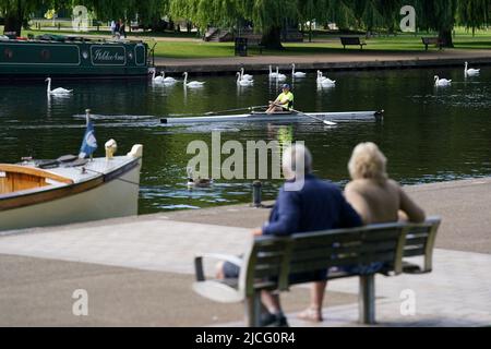 Die Menschen beobachten, wie ein Mann entlang des Flusses Avon in Stratford-upon-Avon, Warwickshire, rudert. Bilddatum: Montag, 13. Juni 2022. Stockfoto