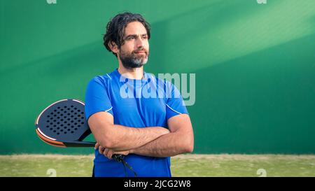 Mann, der Padel-Tennis mit Platz für Text spielt. Kaukasischer Spieler Sportler. Monitor des Padels mit schwarzem Schläger und Kopierraum. Racquet Sport Gam Stockfoto