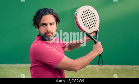 Monitor des Padels mit schwarzem Schläger und Kopierraum. Klasse für Studenten auf dem Tennisplatz im Freien. Mann Paddel-Spieler spielt ein Spiel im Freien. Racque Stockfoto