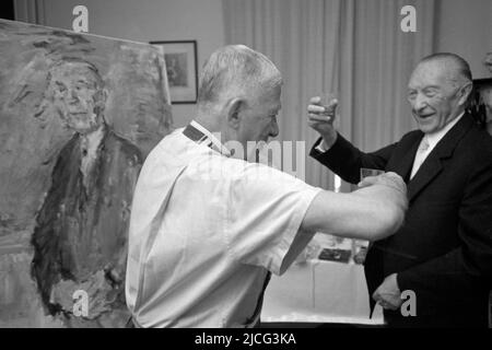 Cadenabbia, Schweiz. 12. Dez 2016. Oskar KOKOSCHKA (l.), Österreich, Maler, Dichter, Grafiker, Malt Konrad ADENAUER, Deutschland, Politiker, ehemaliger Bundeskanzler, CDU, Sie trinken zusammen einen Schnaps; Landschaftsformat; Schwarz-Weiß-Aufnahme ÃÂ Credit: dpa/Alamy Live News Stockfoto