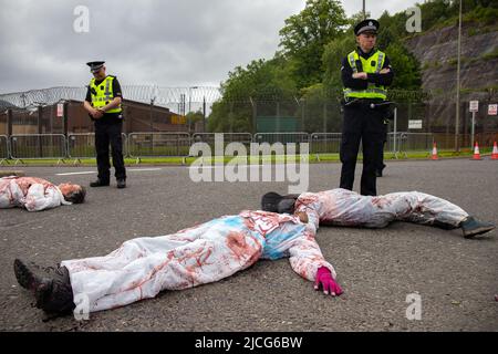 Coulport, Argyll, Schottland 13. Juni 2022 fünf ehemalige Greenham-Frauen und drei Mitglieder von Peace Pirates, einem Ableger von Trident Plowshares, führen eine Blockade im nuklearen Sprengkopflager von Coulport durch. Die ‘Greenham goss gefälschtes Blut auf sich selbst und inszenierten einen Einfall vor den Toren, der eine Seite des Eingangs in die Basis blockierte, während die Mitglieder von ‘Peace Pirates’ (pensionierter Lehrer Brian Quail, 84, mit einer Herztransplantation und durch einen kürzlichen Schlaganfall behindert, Willemien Hoogendorf aus Holland und Gillean Lawrence, eine Großmutter und Unterstützer von XR Peace) sperrten den Kreisverkehr weiter ein Stockfoto