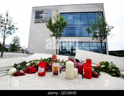 Hamm, Deutschland. 13.. Juni 2022. Blumen und Trauerkerzen liegen vor dem Hörsaalgebäude der Hochschule Hamm. Nach einem Messerangriff eines Mannes, der psychisch krank war, starb eine 30-jährige Frau an ihren Verletzungen. Quelle: Roland Weihrauch/dpa/Alamy Live News Stockfoto