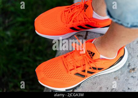 Tjumen, Russland-03. Mai 2022: Adidas Laufschuhe, orange Korallenfarbe, eq21 Lauf. Nahaufnahme des Logos Stockfoto
