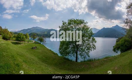 Lago di Ledro ist ein Bergsee mit grün blauem Wasser, grünem Wimsgras an einem Sommertag im Trentino, Norditalien Stockfoto