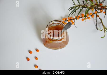 Hausgemachte Marmelade. Glas mit Sanddornmarmelade auf rustikalem Hintergrund. Konservierte Beere. Speicherplatz kopieren Stockfoto