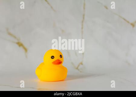 Gelbe Gummiente zum Schwimmen auf Marmorboden Stockfoto