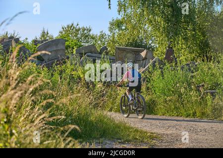 Aktive ältere Frau mit Elektro-Mountainbike auf Tour zum Birkenkopf, einem Gipfel aus Trümmern des 2. Weltkrieges, hoch über der Stadt Stuttgart, Deutschland Stockfoto