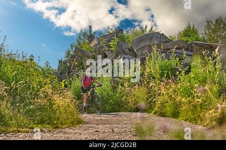 Aktive ältere Frau mit Elektro-Mountainbike auf Tour zum Birkenkopf, einem Gipfel aus Trümmern des 2. Weltkrieges, hoch über der Stadt Stuttgart, Deutschland Stockfoto