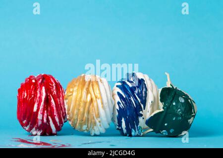 Bunte Kuchen oder Marschmalven bedeckt mit mehrfarbigem Glasur auf blauem Hintergrund fallen gelassen. Kreatives Süßes. Schönes ungewöhnliches Dessert. Stockfoto
