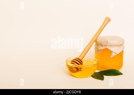 Honig im Glas mit Blättern und Honigtaube auf farbigem Hintergrund Draufsicht mit Text kopieren. Stockfoto