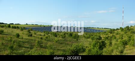 Großer Panoramablick auf große Solarpaneelstation auf den Hügeln auf einer Sommerlandschaft von oben Stockfoto