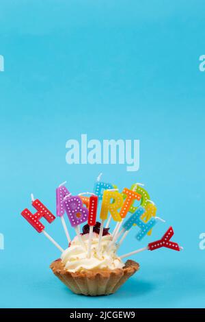 Cupcake mit regenbogenfarbenen Kerzen zum Geburtstag mit der Aufschrift 'Happy Birthday' Stockfoto