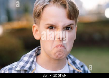 Freche Teenager-Blondine macht Gesichter, schwelgt und dumm herum. Unbeschwerte Kindheit, moderne Jugend Stockfoto