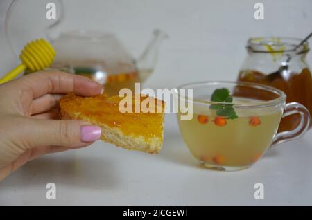 Die Idee des Schutzes und der Behandlung der Grippe mit Volksmitteln mit den gesunden Sanddornbeerenzweigen mit Beeren, mit Tee und Honig. Marmelade Stockfoto