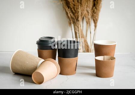 Viele verschiedene Bastelpapier Einwegbecher. Set von Bastelpappbecher für Kaffee oder Tee auf grauem Hintergrund. Zero Waste, plastikfreies Konzept. Stockfoto