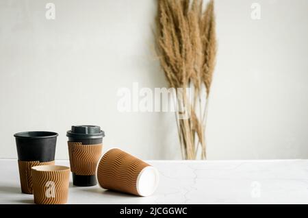Viele verschiedene Bastelpapier Einwegbecher. Set von Bastelpappbecher für Kaffee oder Tee auf grauem Hintergrund. Zero Waste, plastikfreies Konzept. Stockfoto