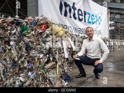 Marl, Deutschland. 13.. Juni 2022. Axel Schweizer, Aktionär und Geschäftsführer, kniet bei einer Pressetour des neuen Umweltdienstleisters Interzero neben recyceltem Abfall. Im Zuge der Aufspaltung der Alba-Abfallgruppe hat Axel Schweizer, einer der Eigentümer, ein neues Unternehmen gegründet. In Marl wurde die Firma Interzero vorgestellt, die sich unter anderem auf die Sortierung und Verarbeitung von Kunststoffabfällen spezialisiert hat. Quelle: Bernd Thissen/dpa/Alamy Live News Stockfoto