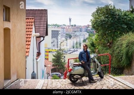 Ein Mann in der Stadt mit Motorroller Stockfoto