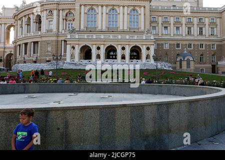 Odessa, Ukraine. 12.. Juni 2022. Ein Kind, das vor einem nicht funktionierenden Brunnen mit Sandsäcken im Hintergrund in der Nähe des Gebäudes der staatlichen Akademischen Oper und des Balletttheaters Odessa während der russischen Invasion in die Ukraine stand. Kredit: SOPA Images Limited/Alamy Live Nachrichten Stockfoto