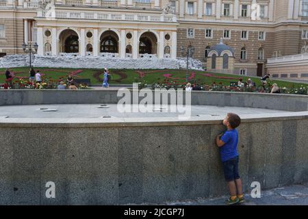 Odessa, Ukraine. 12.. Juni 2022. Ein Kind, das vor einem nicht funktionierenden Brunnen vor dem Hintergrund von Sandsäcken in der Nähe des Gebäudes der Odessa State Academic Opera and Ballet Theatre während der russischen Invasion in der Ukraine stand. Kredit: SOPA Images Limited/Alamy Live Nachrichten Stockfoto