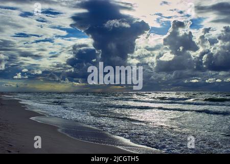 Gewitterwolken über dem Meer. Stürmischer Sonnenuntergang an der ostsee. Blendung auf dem Wasser Stockfoto