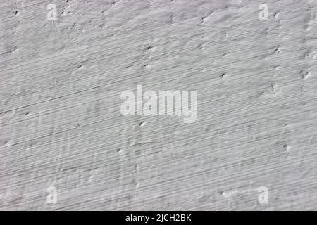 Eine grob verputzte, mit grauer Farbe bemalte Wand. Grungen Hintergrund Stockfoto