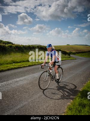 Reife Radfahrerin beim Veloretro Vintage Cycling Event, Ulverston, Cumbria, Großbritannien. Stockfoto