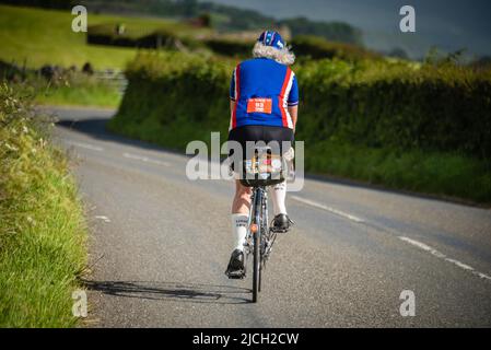 Reife Radfahrerin beim Veloretro Vintage Cycling Event, Ulverston, Cumbria, Großbritannien. Stockfoto