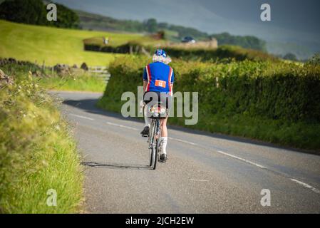 Reife Radfahrerin beim Veloretro Vintage Cycling Event, Ulverston, Cumbria, Großbritannien. Stockfoto