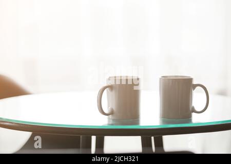 Zwei Tassen Kaffee auf einem Glastisch. Stockfoto