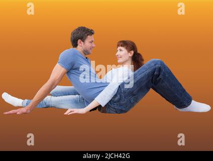 Kaukasisches Paar, das sich anschaut, während es auf gelbem Hintergrund gegen den Kopierplatz sitzt Stockfoto
