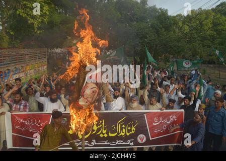 Lahore, Pakistan. 12.. Juni 2022. Aktivisten der pakistanischen Sunniten Tehreek und Shubban Khatm e Nabuwat rufen Slogans, während sie ein Abbild verbrennen, das die ehemalige Sprecherin der Bharatiya Janata Party, Nupur Sharma, während eines Protestes gegen Sharmas Äußerungen zum Propheten Mohammed in Lahore, Pakistan, am 12. Juni 2022 darstellt. (Foto von Rana Sajid Hussain/Pacific Press/Sipa USA) Quelle: SIPA USA/Alamy Live News Stockfoto