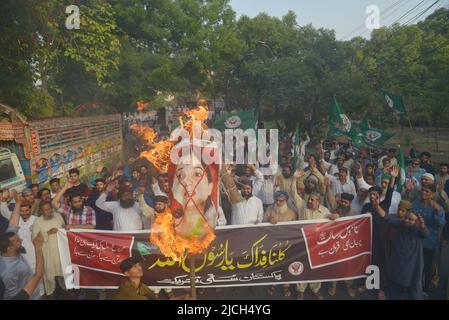 Lahore, Pakistan. 12.. Juni 2022. Aktivisten der pakistanischen Sunniten Tehreek und Shubban Khatm e Nabuwat rufen Slogans, während sie ein Abbild verbrennen, das die ehemalige Sprecherin der Bharatiya Janata Party, Nupur Sharma, während eines Protestes gegen Sharmas Äußerungen zum Propheten Mohammed in Lahore, Pakistan, am 12. Juni 2022 darstellt. (Foto von Rana Sajid Hussain/Pacific Press/Sipa USA) Quelle: SIPA USA/Alamy Live News Stockfoto