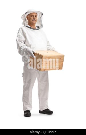 Bienenpfleger in einer Uniform, die eine Holzkiste auf weißem Hintergrund isoliert hält Stockfoto