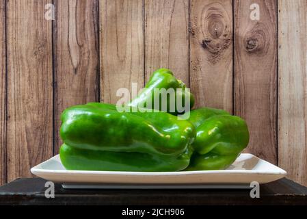 Weißes Porzellantablett mit frischen grünen Paprika bereit, um Salate zuzubereiten Stockfoto