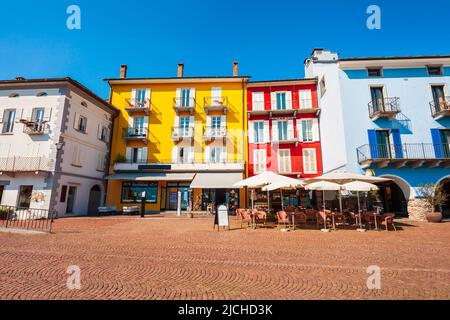 Straßencafé und farbenfrohe Häuser in Ascona, in der Nähe der Stadt Locarno am Ufer des Lago Maggiore im Kanton Tessin in der Schweiz. Stockfoto
