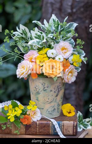 Strauß Rosen, Viola Blumen und Blätter in Vase im Garten Stockfoto