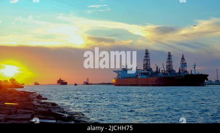 PORT ARANAS, TX - 21. FEB 2020: Wunderschöner Sonnenuntergang mit drei Öltankern, die sich von Corpus Christi, Texas, auf dem Wasser des Schiffskanals nähern Stockfoto