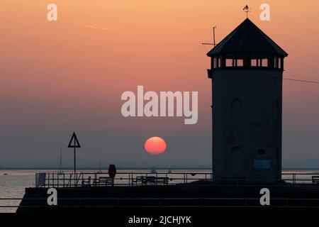 Die untergehende Sonne bei Brightlingsea in Essex UK. Bateman's Tower im Vordergrund. Stockfoto