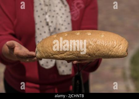 Ukrainische alte Frau, die Brot in den Händen hält, aus der Nähe Stockfoto