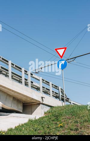 Blick auf die Betonbrücke neben der Straße. Sichtbar - nachgeben - Zeichen. Stockfoto