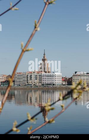 Lettische Akademie der Wissenschaften. Schöner Blick über die Daugava mit einer perfekten Reflexion im blauen Wasser. Stockfoto