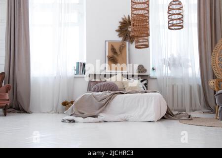 Bett mit Kissen und eine Decke in einer Wohnung in der Nähe des Fensters, Schlafzimmer im Haus, Möbel und Dekor der Wohnung, Haus Stockfoto
