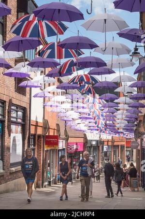 Farbenfrohe Regenschirme oder Sonnenschirme über den Käufern im Prince Bishops Shopping Centre, Durham City, England, Großbritannien Stockfoto