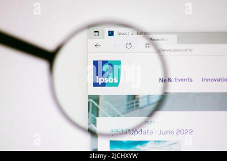 In dieser Abbildung ist die Homepage der Website der Ipsos Group auf einem Computerbildschirm durch ein Vergrößerungsglas zu sehen. Stockfoto