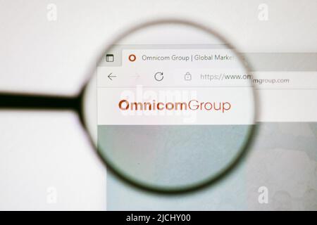 In dieser Abbildung ist die Homepage der Omnicom Group-Website auf einem Computerbildschirm durch eine Lupe zu sehen. Stockfoto