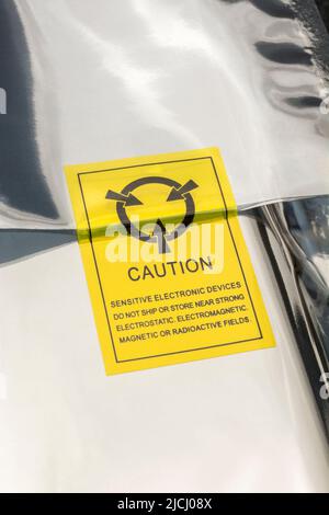 Versilberter antistatischer Kunststoffverpackungsbeutel mit einem antistatischen Warnsymbol oder -Symbol. Für empfindliche elektronische Bauteile, statisches Elektrizitätskonzept. Stockfoto