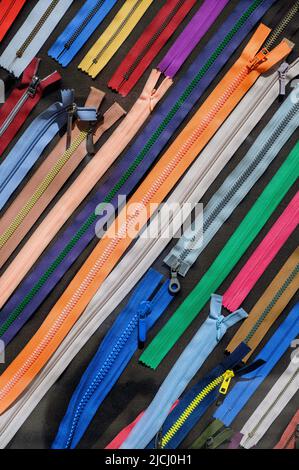 Viele Reißverschlüsse in verschiedenen Farben. atelier, Stoff und Accessoires Shop. Stockfoto